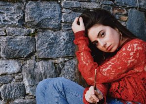 alt="eve seduta con maglione rosso"/